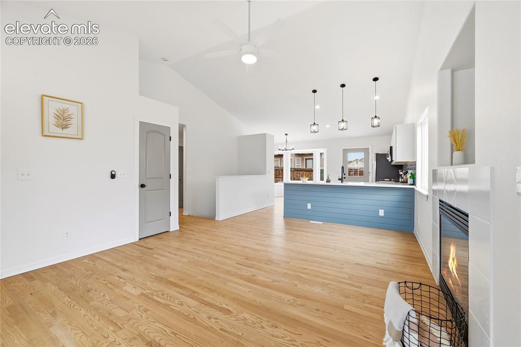 Image 5 of 30: Open-concept living space featuring wood-finish flooring, a vaulted ceiling