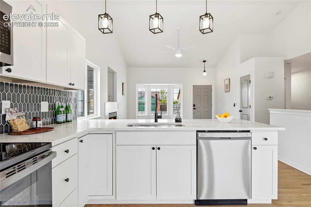 Image 8 of 30: Contemporary kitchen featuring white cabinetry, light-toned countertops, an
