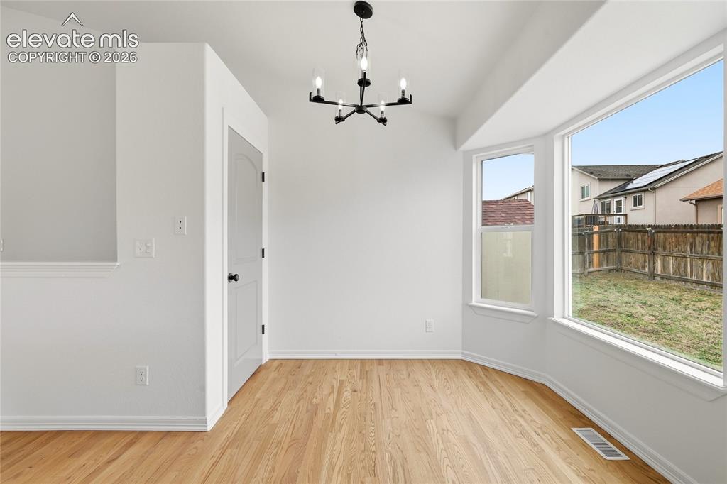 Image 9 of 30: Room featuring bay windows, light wood-finish flooring, a modern black chan