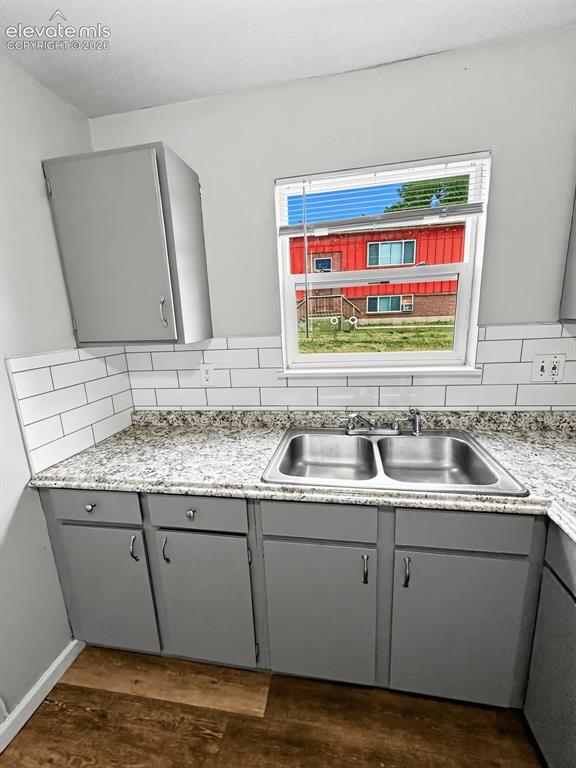 Image 13 of 23: Kitchen area featuring a double basin stainless steel sink, speckled counte