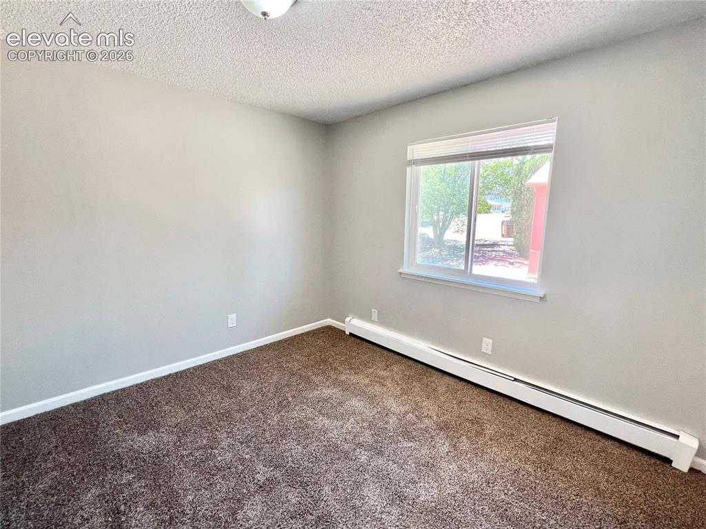 Image 17 of 23: Room featuring neutral wall paint, textured ceiling, brown carpet flooring,