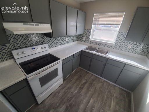 Image 21 of 23: Kitchen featuring gray cabinetry, light-colored countertops, a tile backspl
