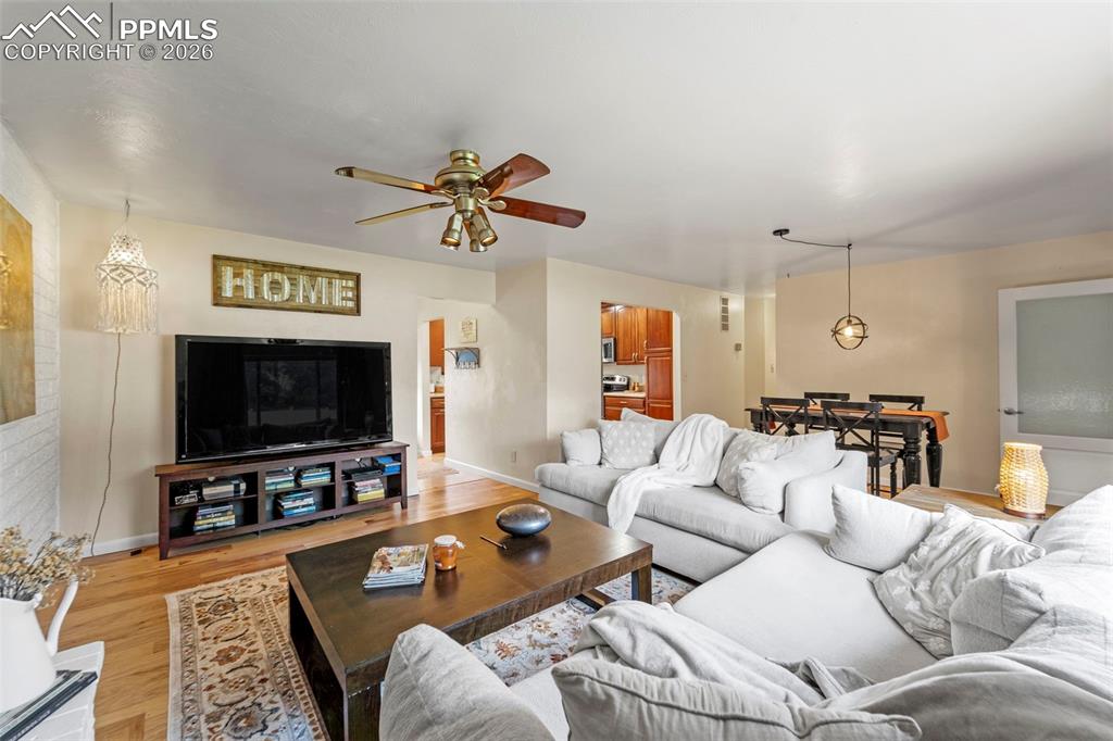 Image 16 of 41: Living area with a ceiling fan and light wood-style flooring