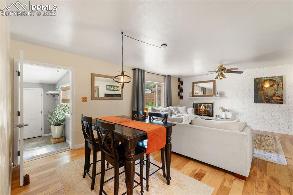 Image 18 of 41: Dining room with light wood-type flooring, ceiling fan, a glass covered fir