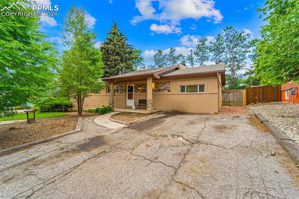 Image 3 of 41: View of front of home with stucco siding, covered porch, a shingled roof, a