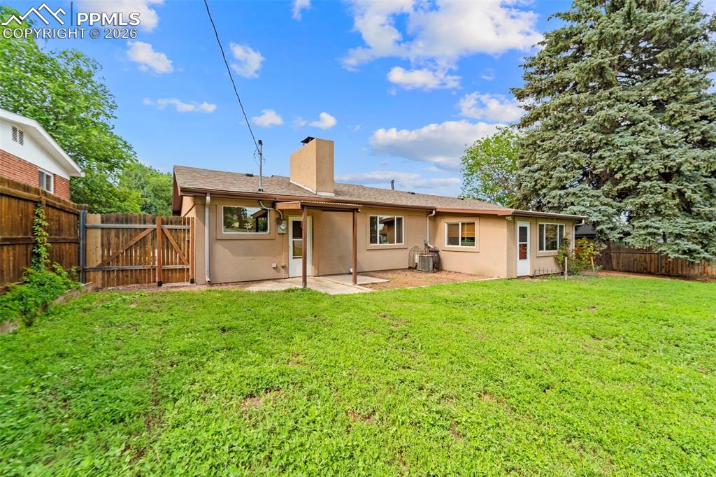 Image 33 of 41: Back of property with a fenced backyard, a patio, a chimney, stucco siding,