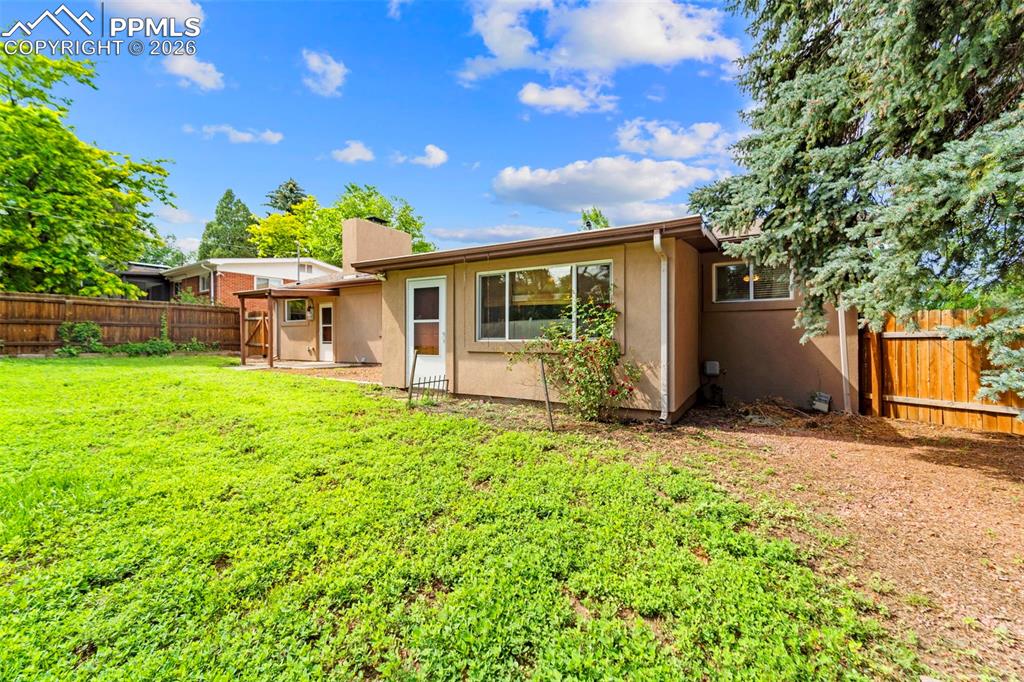 Image 35 of 41: Rear view of house with a fenced backyard, a patio, stucco siding, and a ch