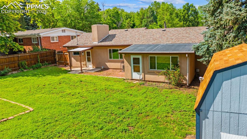 Image 37 of 41: Rear view of house with a chimney, a fenced backyard, a shingled roof, a pa