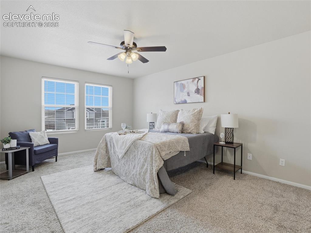 Image 21 of 45: Carpeted room featuring two windows with horizontal blinds, a ceiling fan w