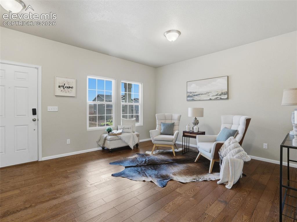 Image 3 of 45: Spacious living area featuring wood-finish flooring, light-colored walls, m