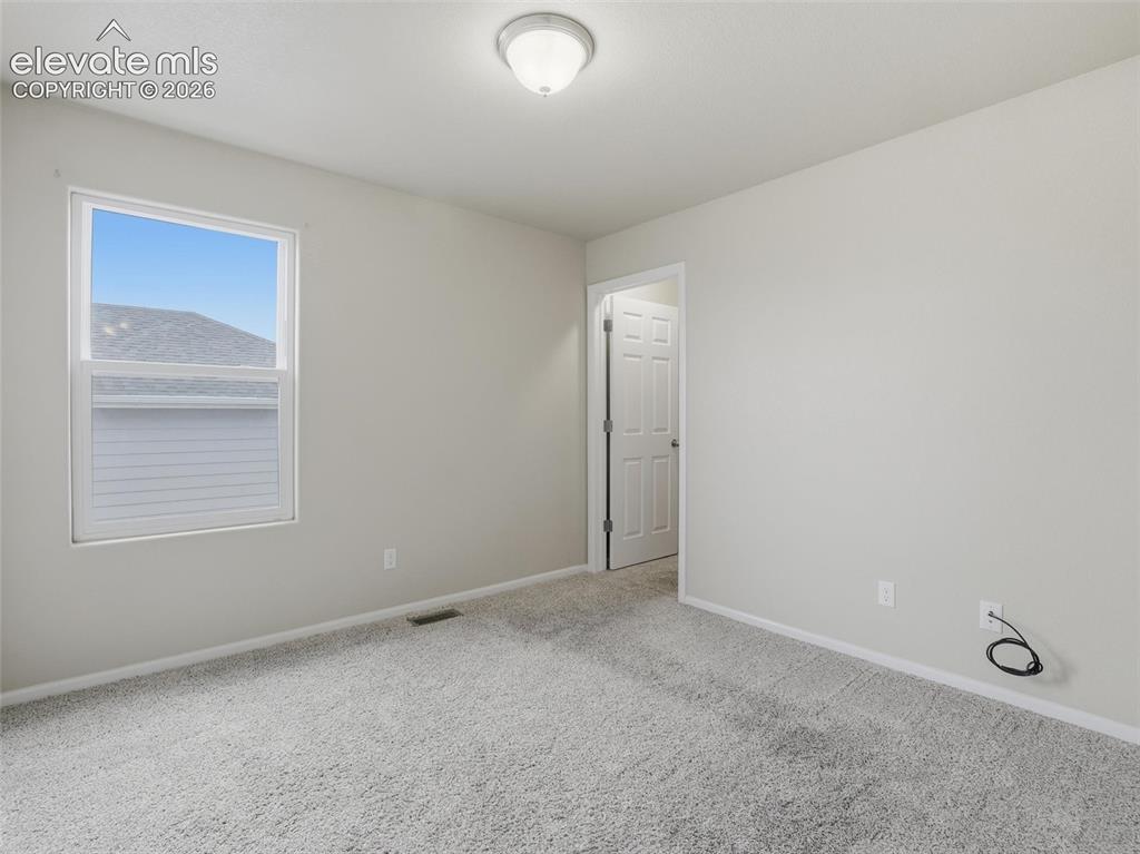 Image 31 of 45: Room featuring light gray wall paint, gray carpet, and a multi-pane window