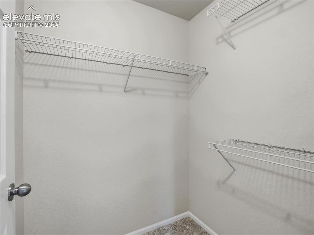 Image 32 of 45: Walk-in closet with multiple wire shelving units, light gray walls, and neu