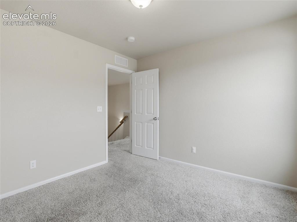 Image 33 of 45: Spacious room featuring light-colored walls and soft carpet flooring