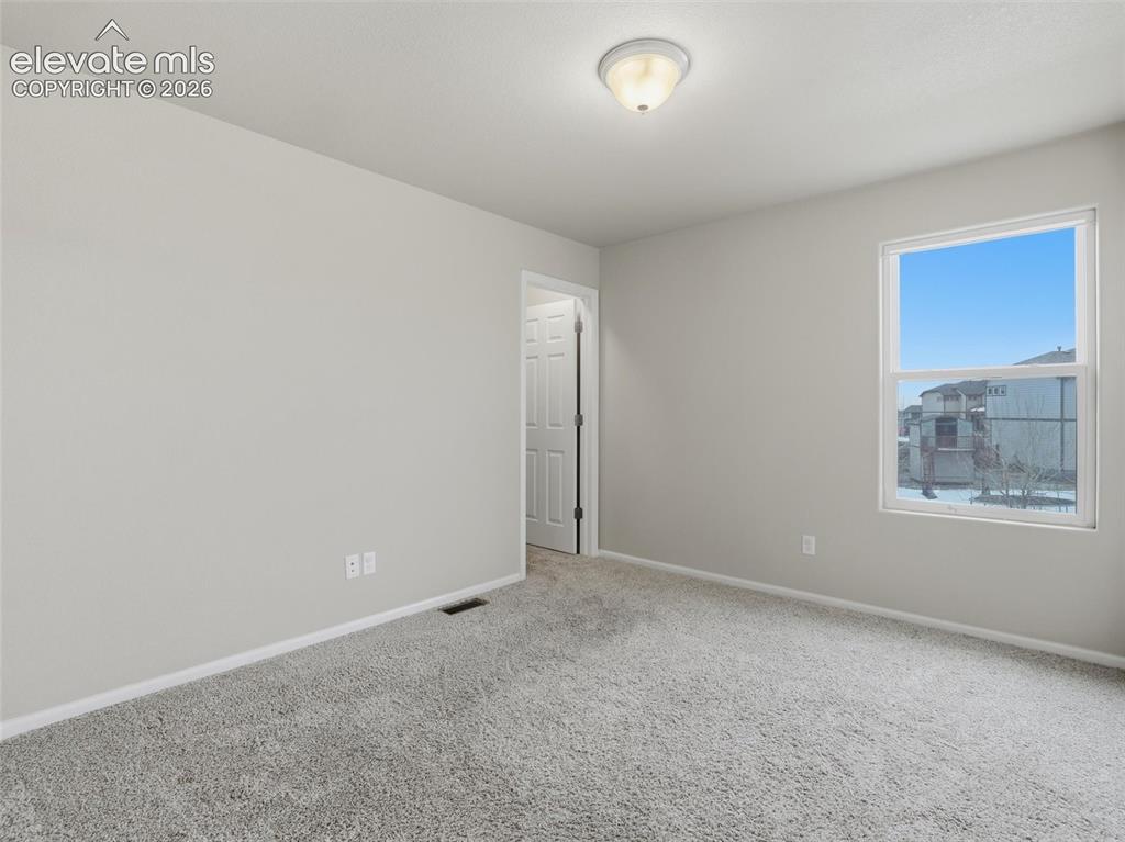 Image 35 of 45: Neutral-toned walls complement the gray carpeting