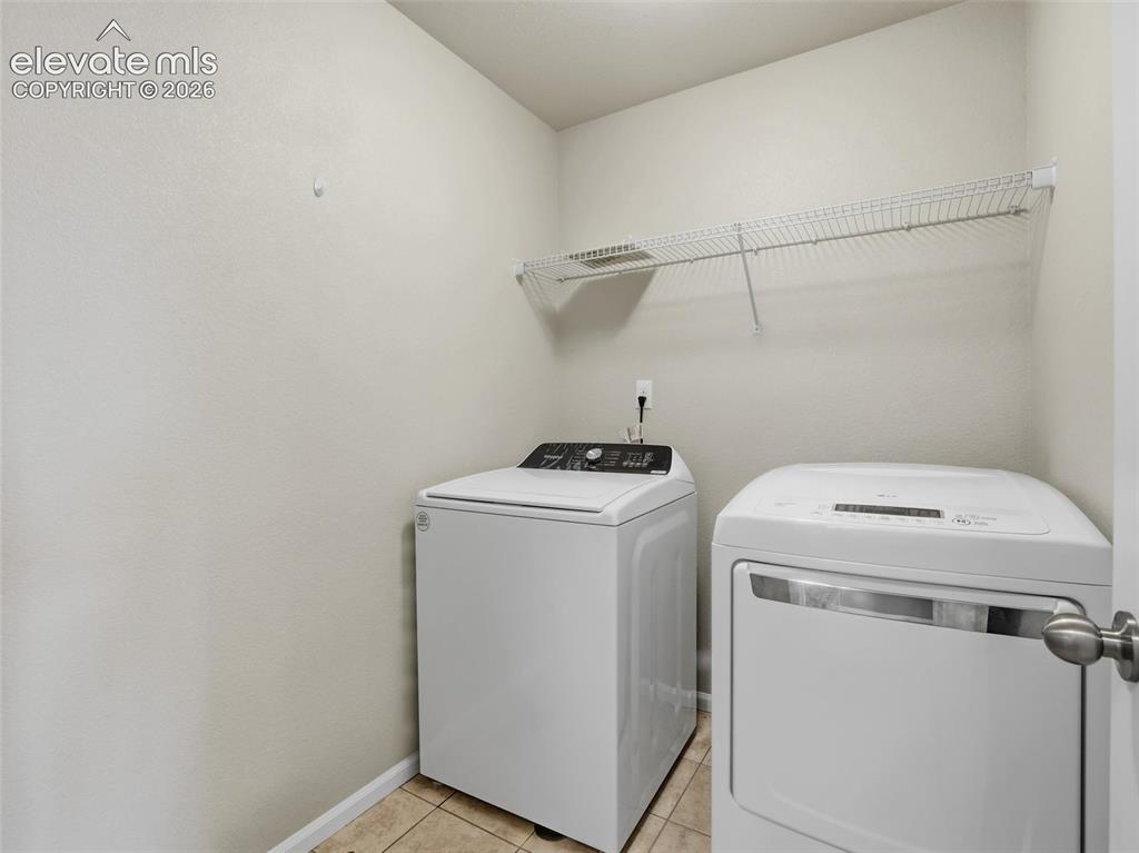 Image 38 of 45: Laundry area with tiled flooring, neutral wall tones, and a wall-mounted wi