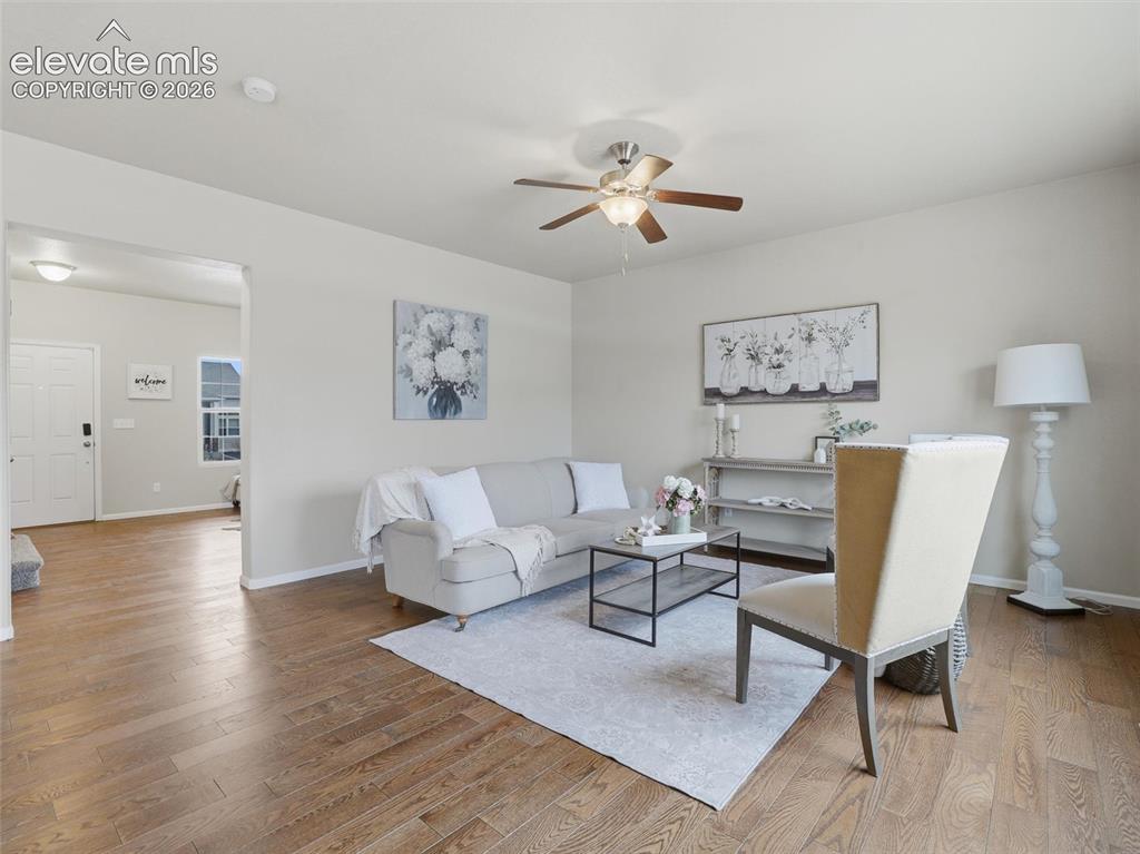 Image 4 of 45: Spacious living area featuring wood-finish flooring, neutral wall tones, an