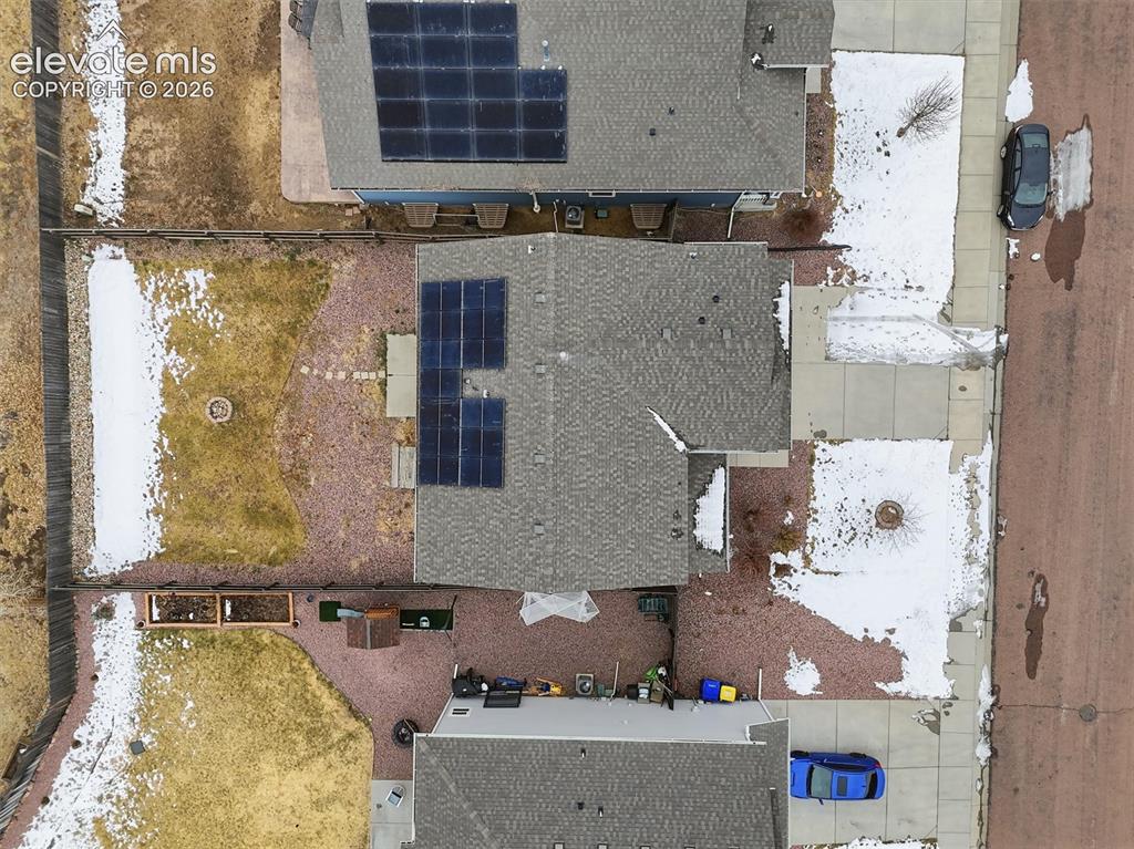 Image 43 of 45: Shingle roof property featuring rooftop solar panels and a landscaped backy