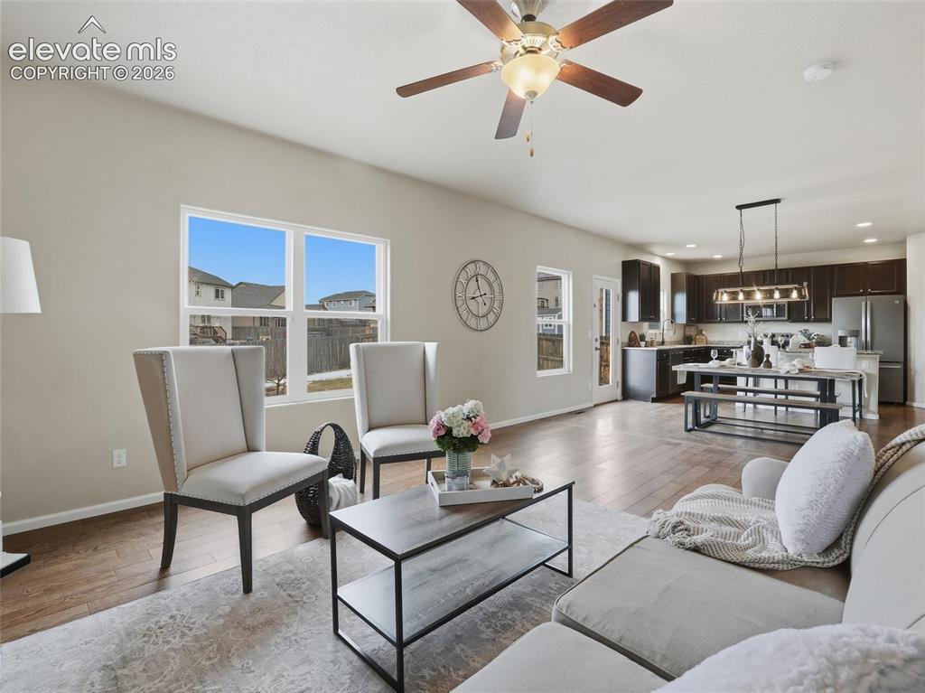 Image 5 of 45: Open-concept living space featuring wood-finish flooring and neutral wall t