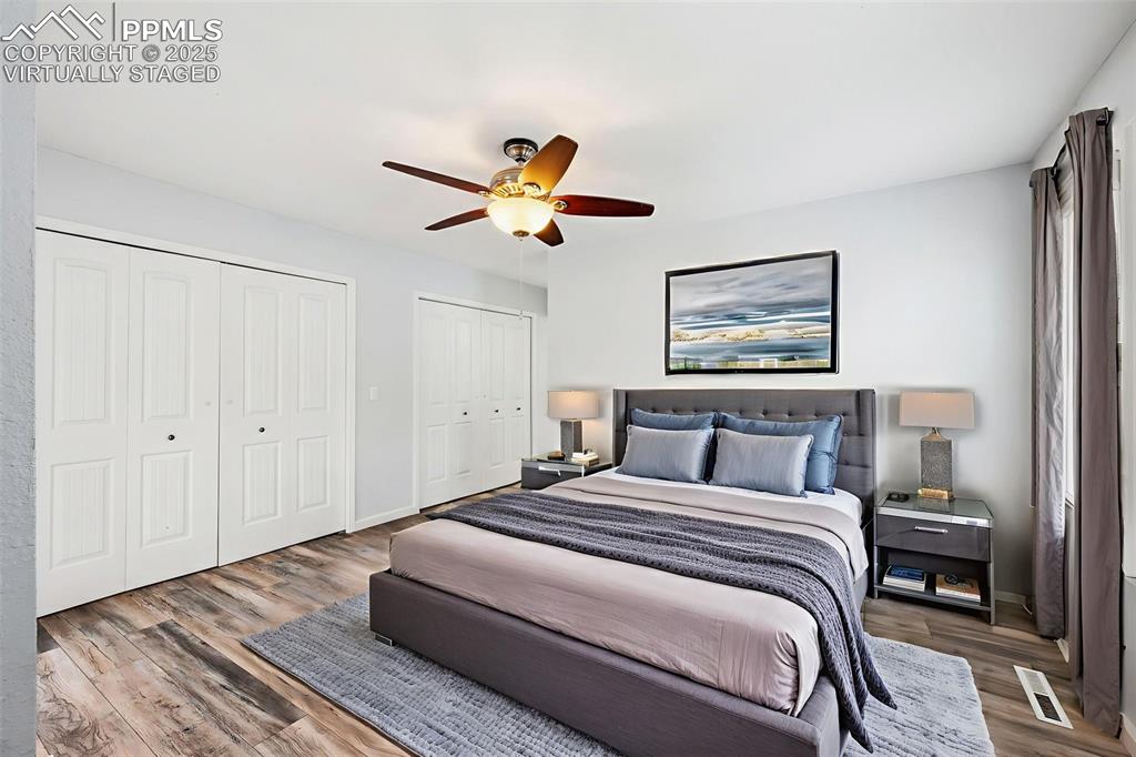 Image 10 of 31: Virtually staged primary bedroom with a ceiling fan with light, laminate fl