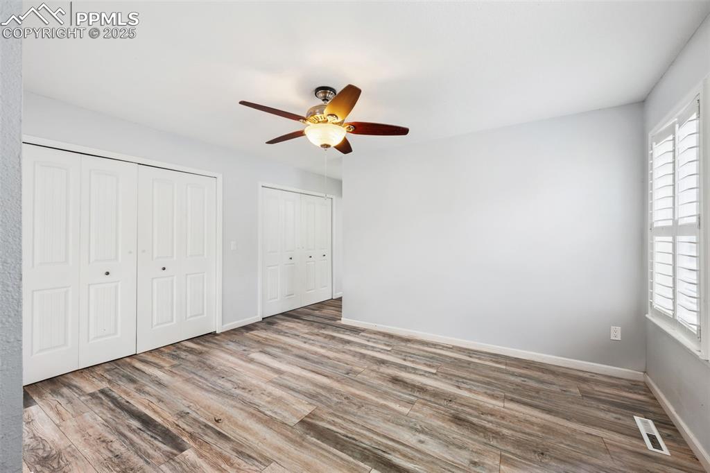 Image 11 of 31: Unfurnished primary bedroom with a ceiling fan with light, laminate floorin