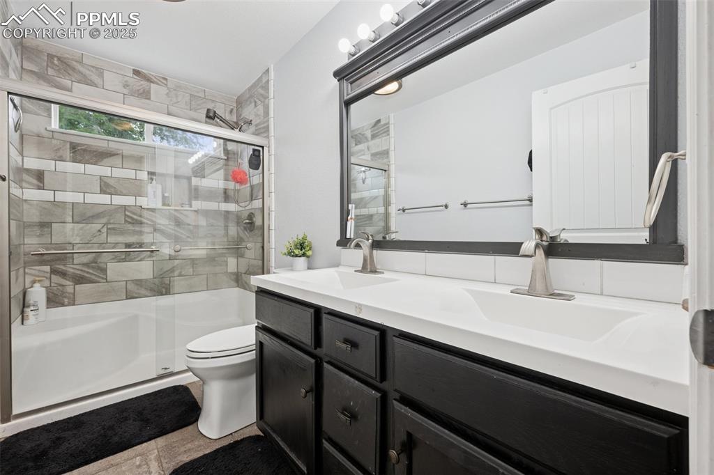 Image 13 of 31: Full bath with a tile shower and double vanity