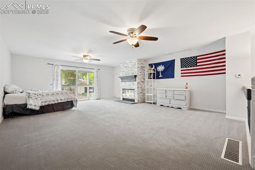 Image 17 of 31: Loft with carpet floors, 2 ceiling fans with lights, a fireplace, access to