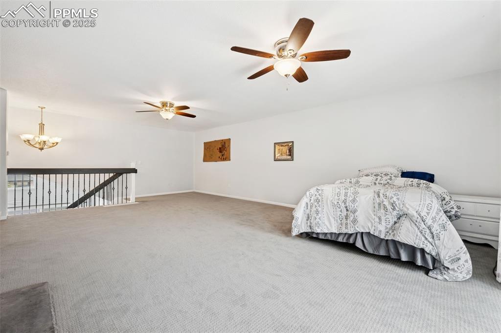 Image 18 of 31: Loft with carpet floors, 2 ceiling fans with lights, a fireplace, access to