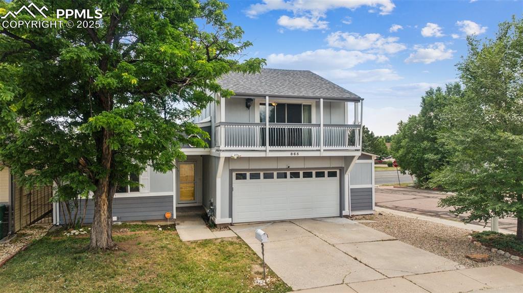 Image 2 of 31: View of front of house with a balcony, an attached garage, concrete drivewa