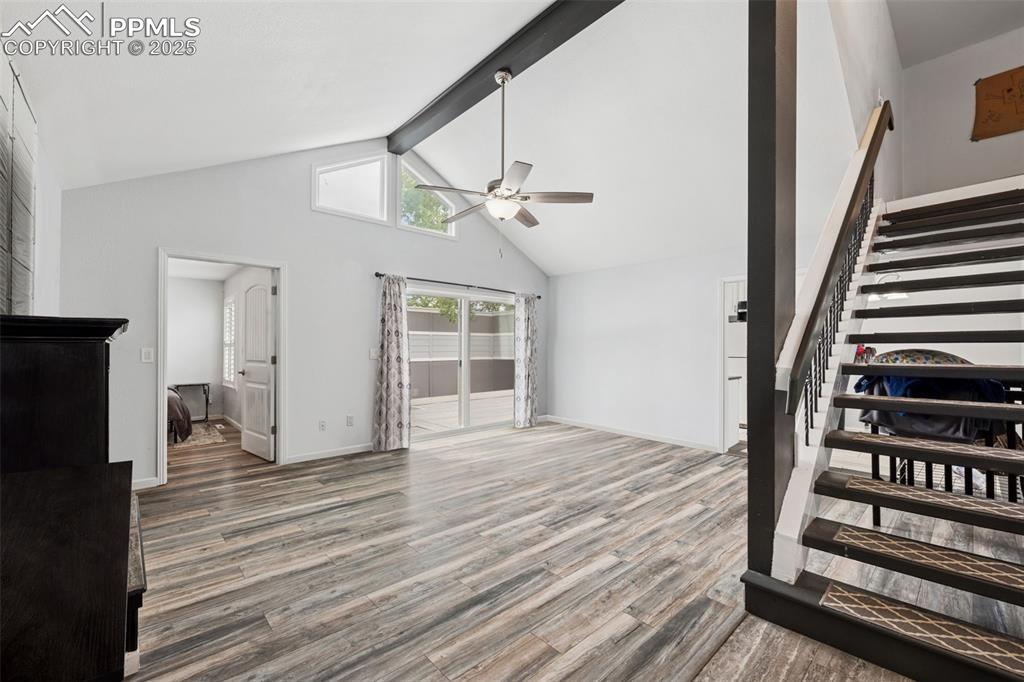 Image 3 of 31: Living room featuring ceiling fan, fireplace, stairs, laminate floors, wal