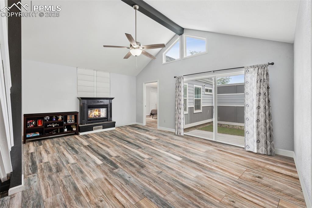 Image 4 of 31: Living room featuring ceiling fan, fireplace, stairs, laminate floors, walk