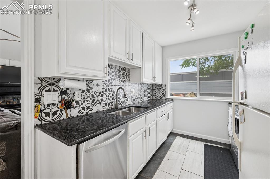 Image 6 of 31: Kitchen featuring white appliances, white cabinets, granite countertops and