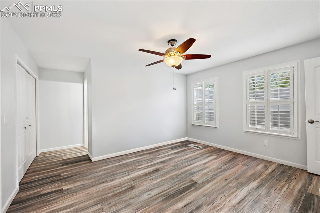 Image 9 of 31: Unfurnished primary bedroom with a ceiling fan with light, laminate floorin