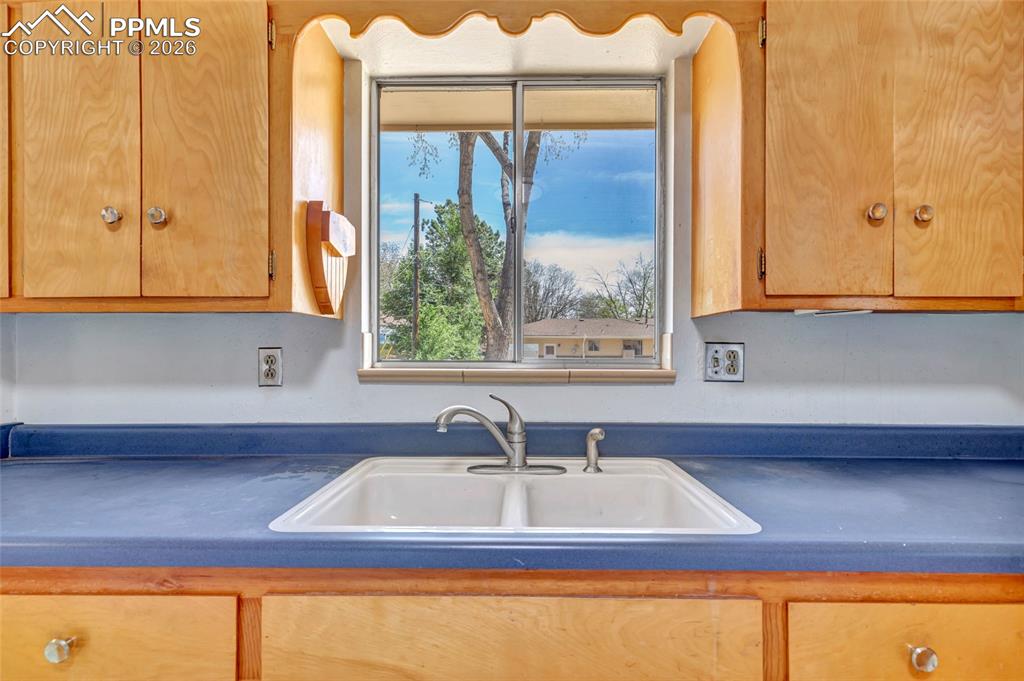 Image 12 of 36: Dual-basin sink with a chrome faucet, set into a blue countertop, complemen