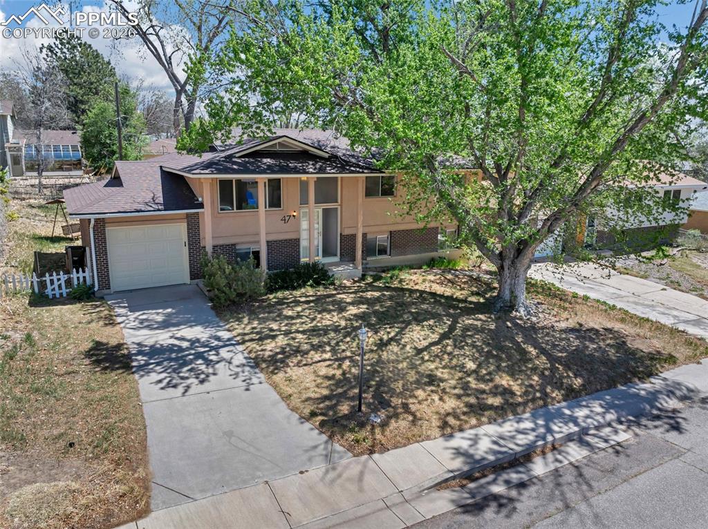 Image 2 of 36: Split-level residence featuring a single-car garage and a concrete driveway