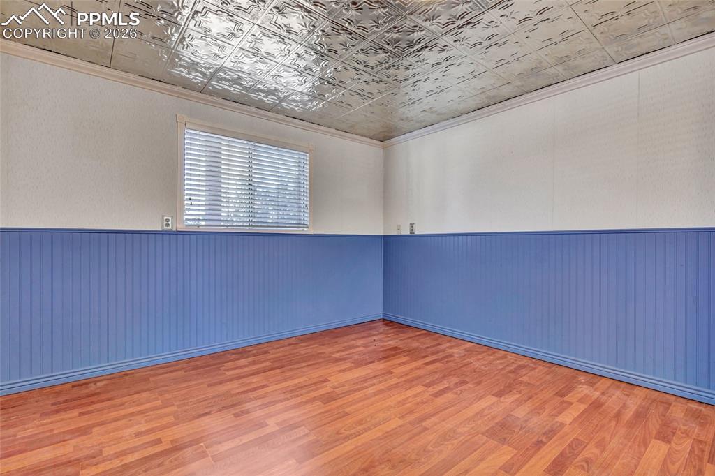 Image 24 of 36: Room featuring wood-finish flooring, blue wainscoting, and a white embossed