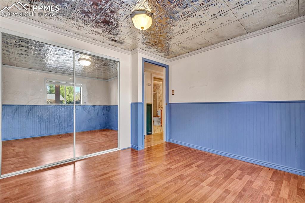Image 25 of 36: Room featuring wood-finish flooring, a decorative pressed tin ceiling, and 
