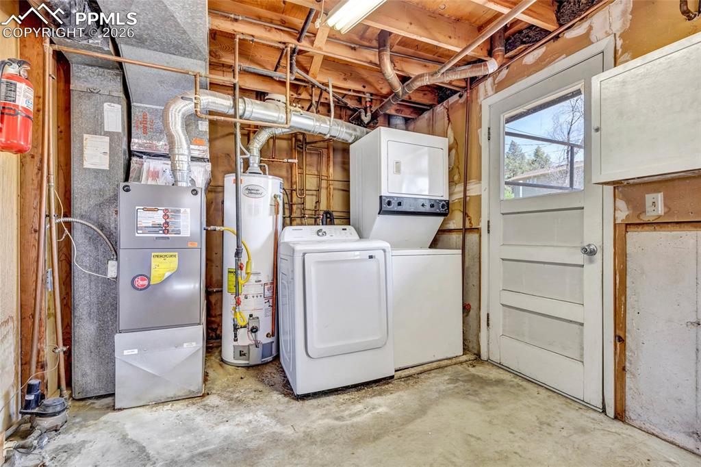 Image 28 of 36: Utility room featuring a furnace, water heater, and laundry appliances