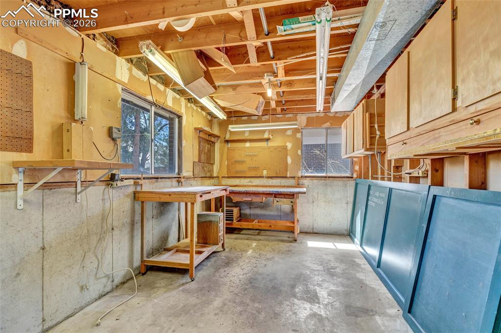Image 29 of 36: Utility space featuring exposed wood ceiling joists, concrete flooring, mul