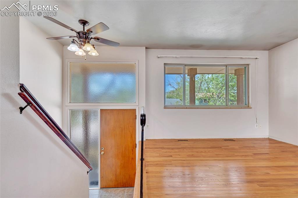 Image 5 of 36: Hardwood flooring throughout a bright living area, featuring a multi-pane w