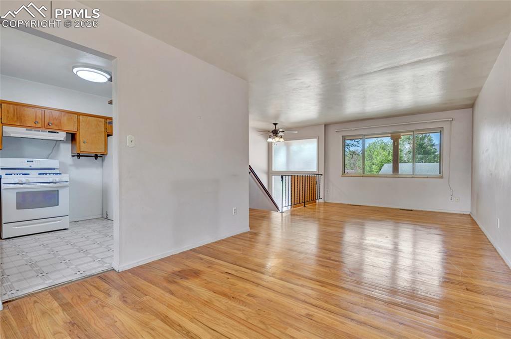 Image 9 of 36: Expansive living area with wood-finish flooring and a large window