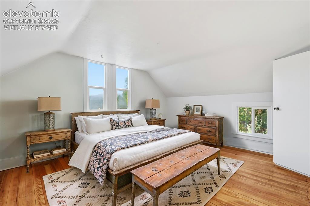 Image 23 of 40: Virtually staged primary bedroom with pine hardwood flooring, painted walls