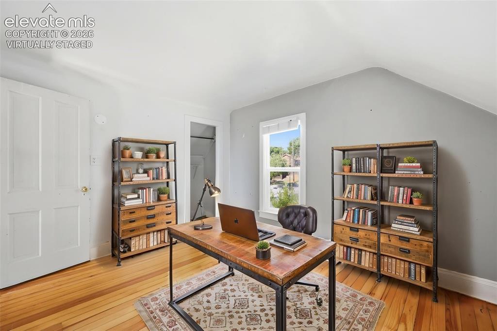 Image 26 of 40: Virtually staged secondary bedroom with pine hardwood flooring, white panel