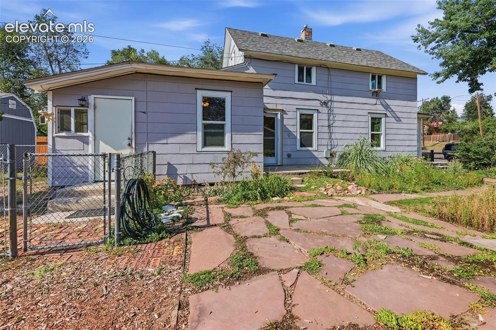 Image 29 of 40: Side of structure exterior featuring a flowerbed, horizontal siding, white 