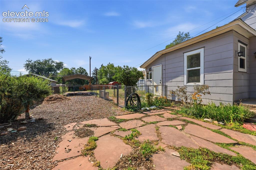 Image 30 of 40: Exterior featuring a metal carport, horizontal siding, white trim windows,