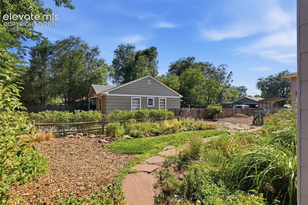 Image 35 of 40: Exterior featuring flower beds and flagstone paving.