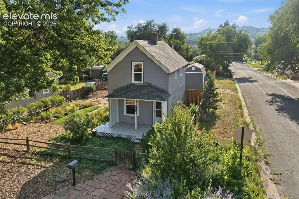 Image 36 of 40: Gray siding exterior with white trim, covered front porch, stone pathway, m
