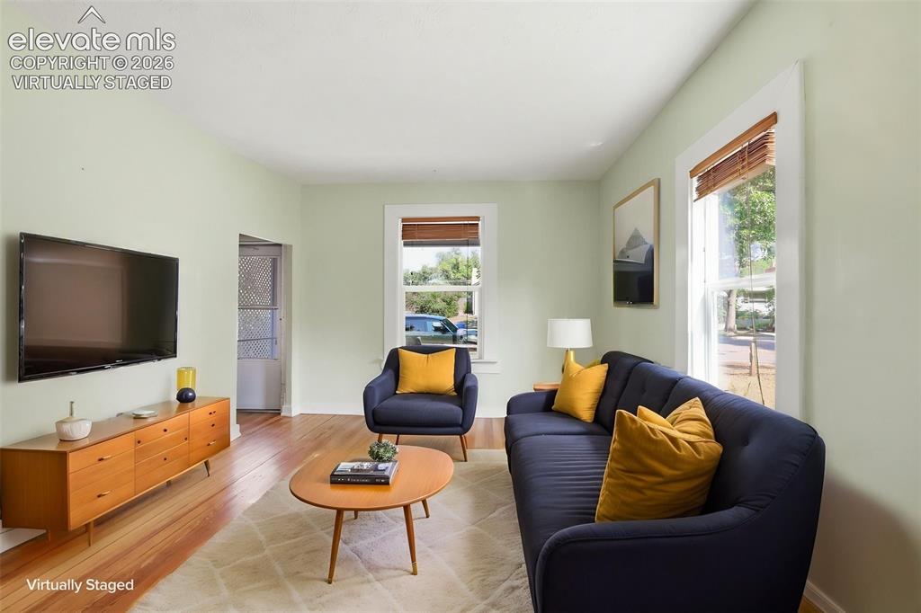 Image 6 of 40: Virtually staged living room with pine hardwood flooring throughout, light