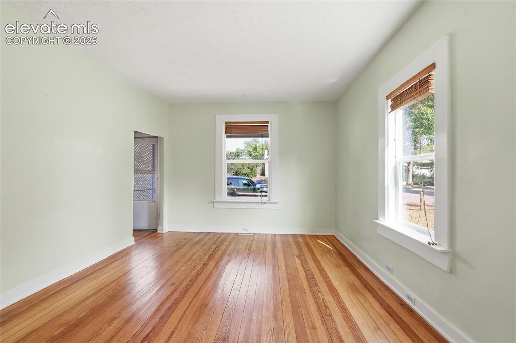 Image 7 of 40: Living room with pine hardwood flooring throughout, light green wall paint,
