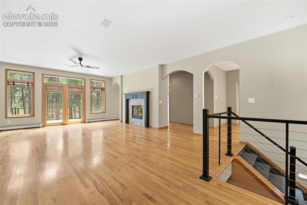 Image 10 of 40: Open-concept living area featuring wood-finish flooring, a contemporary cei
