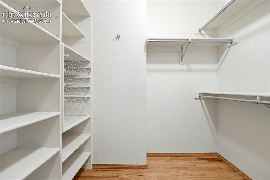 Image 20 of 40: Walk-in closet featuring built-in shelving, wire baskets, and multiple hang